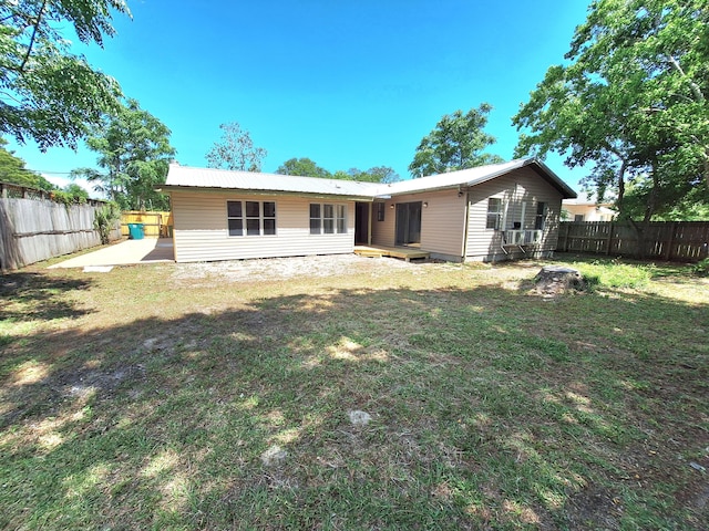back of property featuring a fenced backyard, a yard, and a patio area