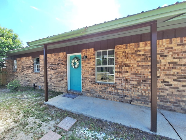 doorway to property featuring brick siding