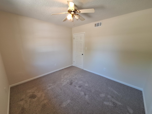 carpeted empty room featuring a ceiling fan, baseboards, visible vents, and a textured ceiling
