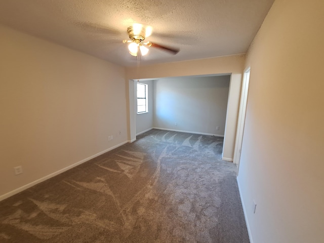 empty room featuring carpet floors, a ceiling fan, a textured ceiling, and baseboards