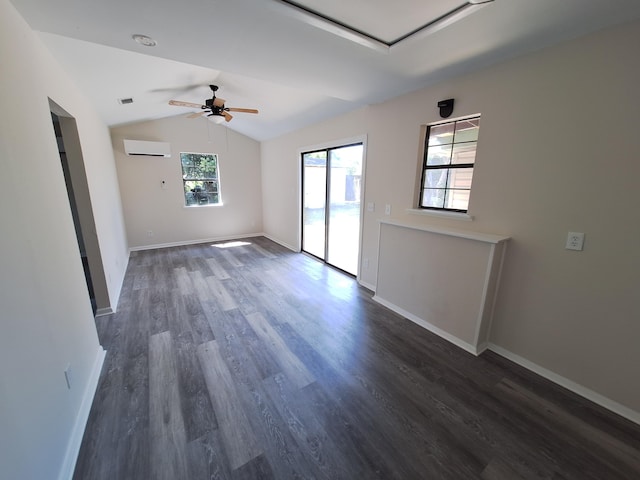 spare room featuring a ceiling fan, baseboards, vaulted ceiling, dark wood-type flooring, and a wall mounted AC