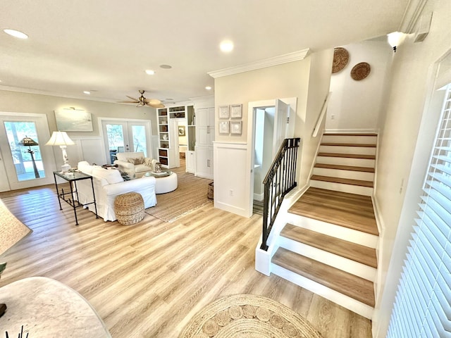 living area with crown molding, stairs, light wood finished floors, ceiling fan, and recessed lighting