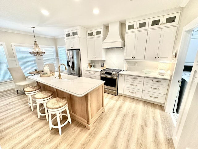 kitchen with custom exhaust hood, appliances with stainless steel finishes, light wood finished floors, crown molding, and a breakfast bar area