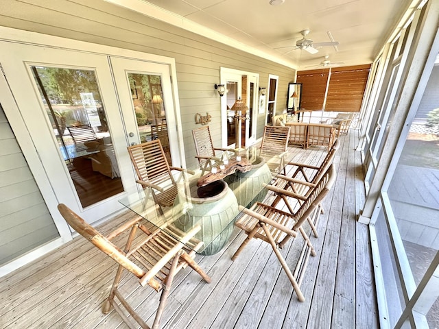 sunroom / solarium featuring a ceiling fan and french doors