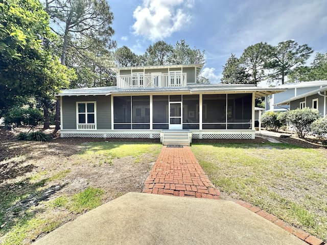 view of front of home with a sunroom and a front lawn