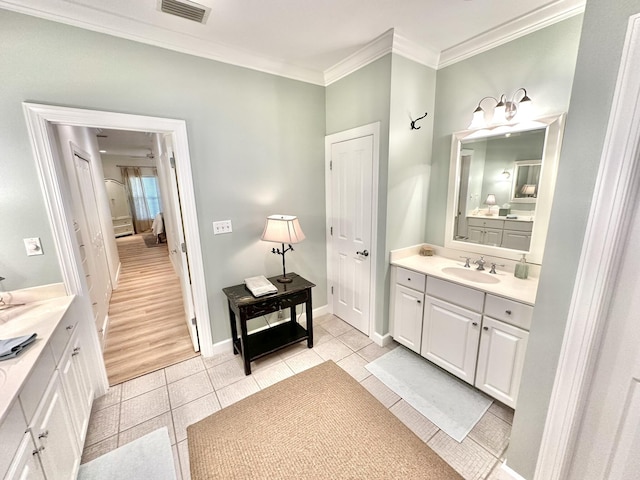 full bath with two vanities, ornamental molding, tile patterned floors, and baseboards