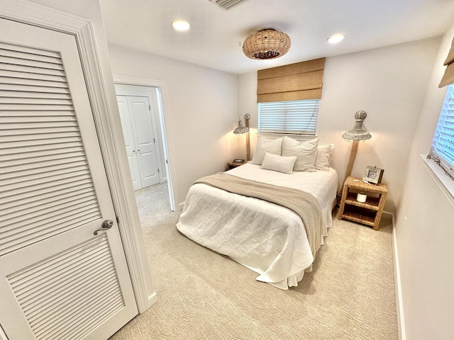 bedroom with light colored carpet, baseboards, and recessed lighting