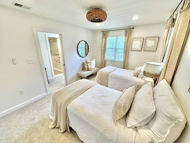 bedroom with light colored carpet, baseboards, and ensuite bathroom