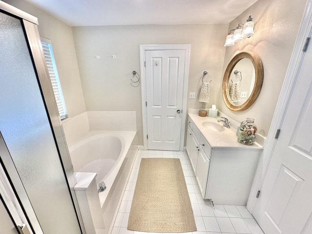 bathroom with tile patterned floors, a garden tub, and vanity