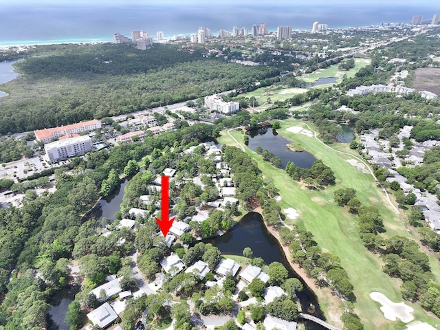 aerial view of property's location with a large body of water, nearby urban area, and a golf course