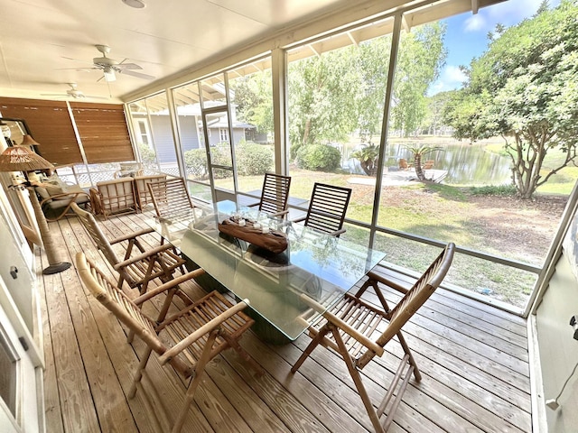 sunroom / solarium featuring ceiling fan, a water view, outdoor dining area, and plenty of natural light