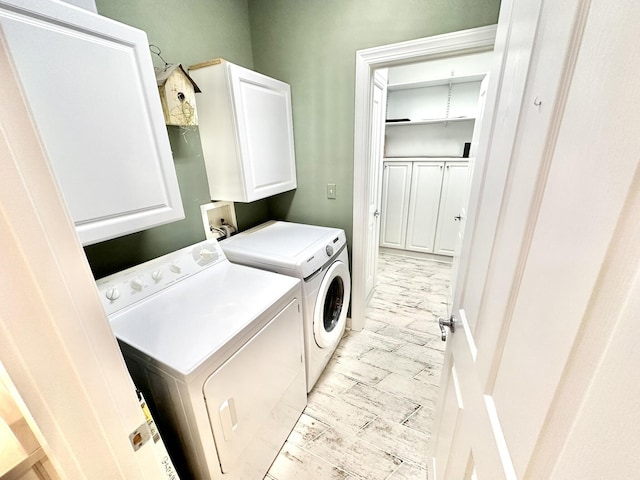 laundry area featuring washing machine and dryer and cabinet space