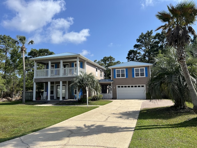 view of front of home with an attached garage, a front yard, a balcony, covered porch, and driveway