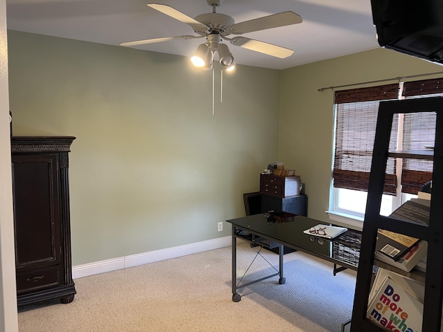 office space with baseboards, a ceiling fan, and light colored carpet