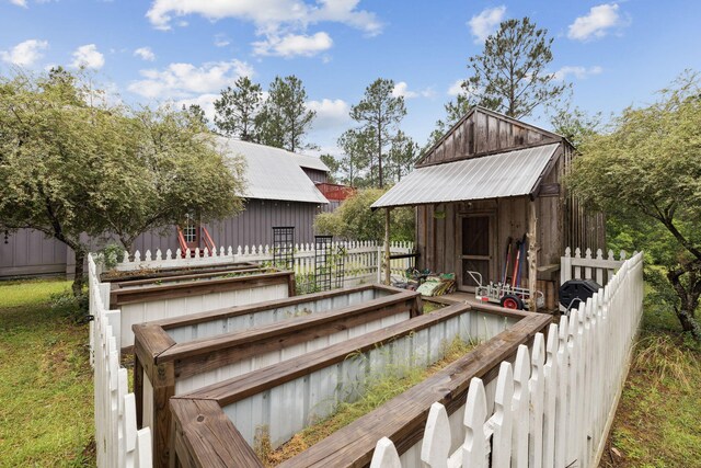 wooden terrace featuring fence, a storage unit, and an outdoor structure