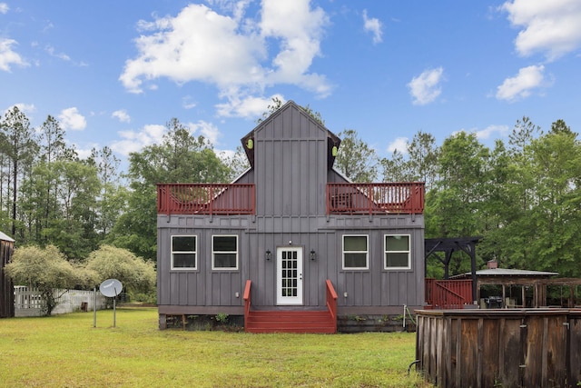 back of house featuring board and batten siding and a lawn