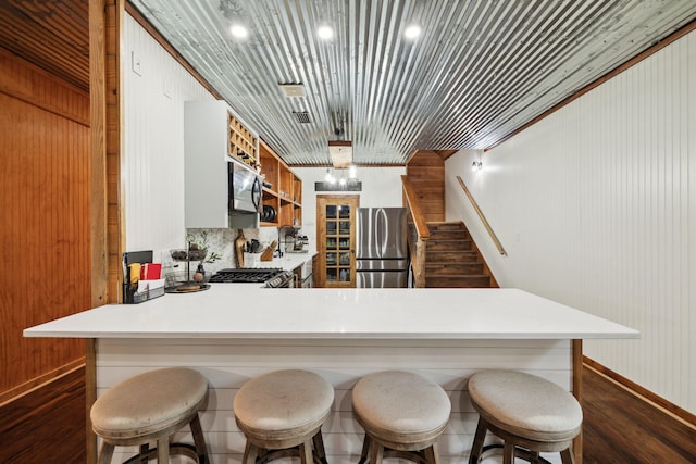 kitchen with baseboards, light countertops, and appliances with stainless steel finishes