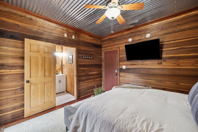 bedroom with a sink, connected bathroom, and wooden walls