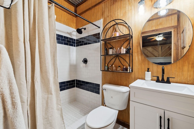 bathroom with toilet, wood walls, a tile shower, and vanity