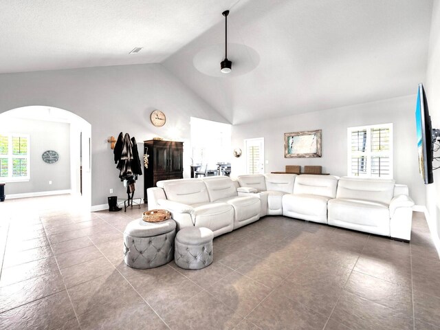 214 Whispering Lake Dr, Santa Rosa Beach, FL 32459 - tiled living room with arched walkways, vaulted ceiling, baseboards, and a ceiling fan
