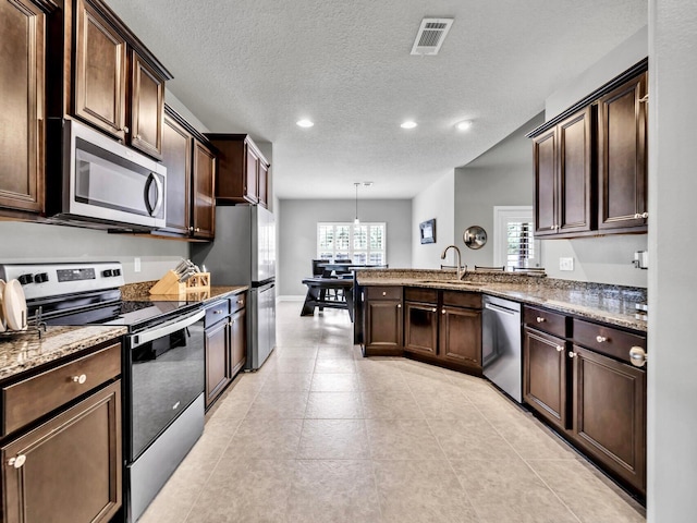 214 Whispering Lake Dr, Santa Rosa Beach, FL 32459 - kitchen with a sink, stainless steel appliances, visible vents, recessed lighting, and dark brown cabinetry