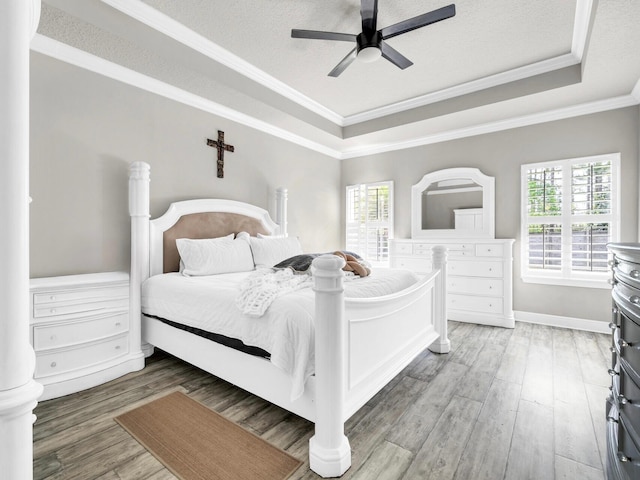 214 Whispering Lake Dr, Santa Rosa Beach, FL 32459 - bedroom with a tray ceiling, multiple windows, wood finished floors, and crown molding