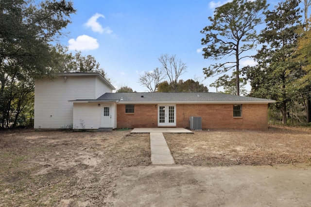 rear view of house featuring brick siding, central air condition unit, and french doors