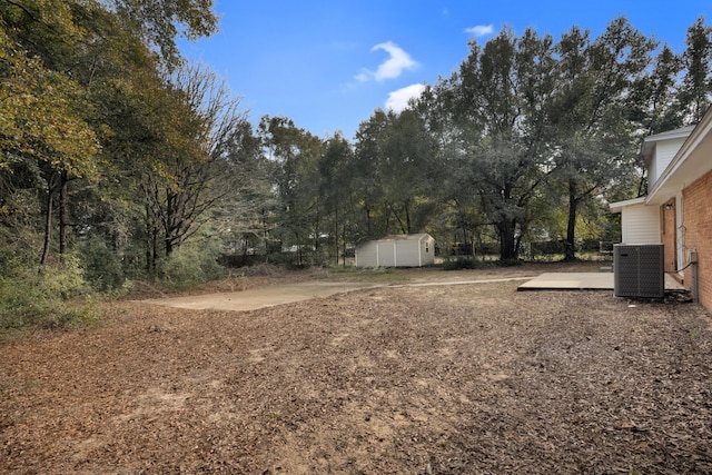 view of yard featuring an outbuilding, a storage shed, and cooling unit