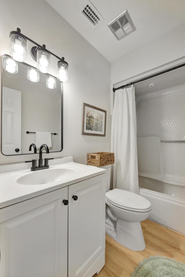 bathroom featuring toilet, visible vents, wood finished floors, and vanity