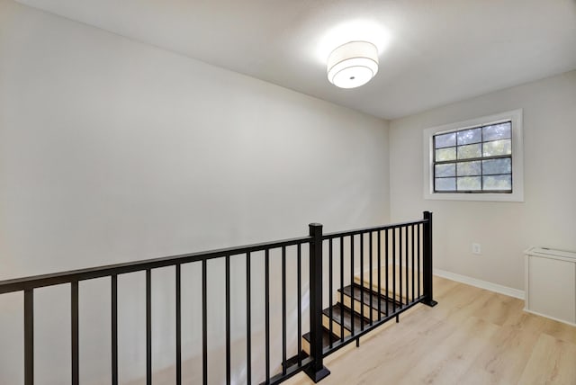 stairway with baseboards and wood finished floors