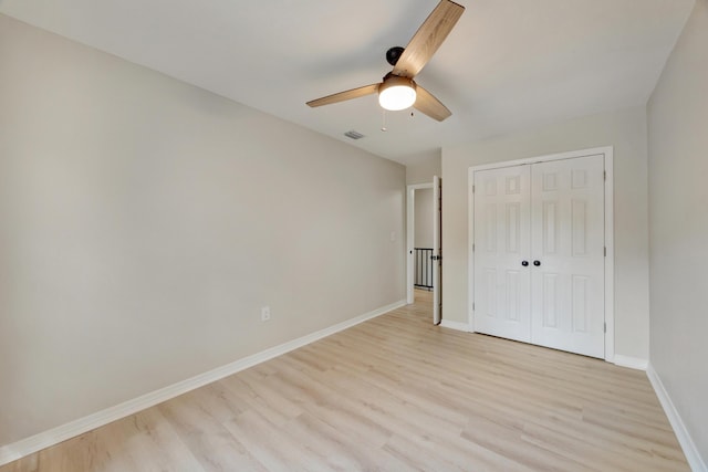 unfurnished bedroom featuring a closet, baseboards, a ceiling fan, and light wood-style floors