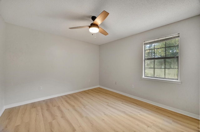 spare room featuring baseboards, ceiling fan, and wood finished floors