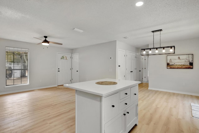 kitchen with a kitchen island, open floor plan, and light wood-type flooring