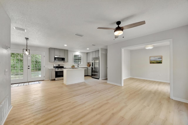 kitchen with gray cabinetry, appliances with stainless steel finishes, light countertops, and open floor plan