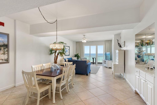 dining room with light tile patterned floors, a ceiling fan, and baseboards