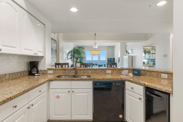 kitchen with black dishwasher, a sink, white cabinetry, decorative backsplash, and light stone counters