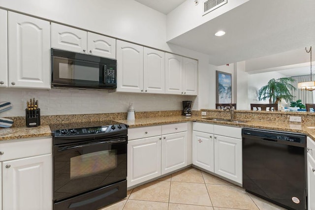 kitchen with black appliances, a sink, white cabinets, light tile patterned floors, and light stone countertops