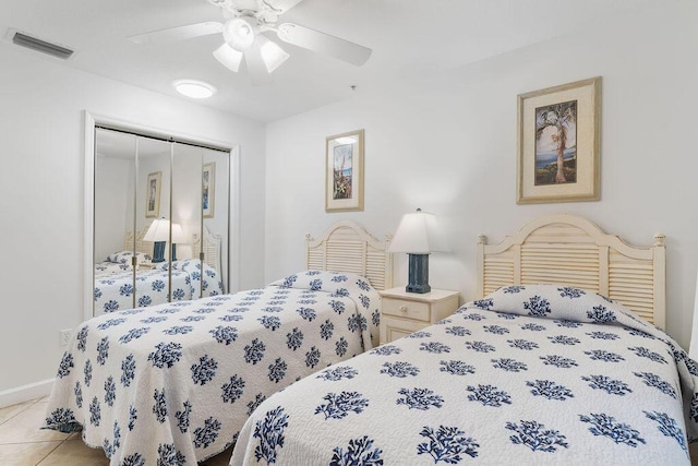tiled bedroom with a closet, ceiling fan, and baseboards