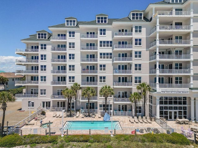 view of apartment building / complex featuring a community pool and fence