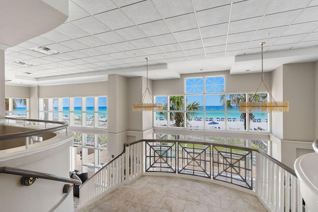 hallway featuring a drop ceiling and a water view