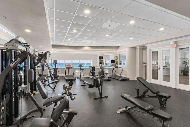 gym with a drop ceiling and french doors