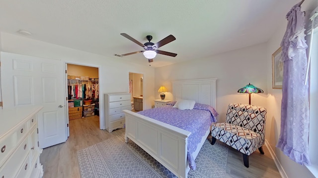 bedroom featuring light wood-style floors, a walk in closet, a closet, and visible vents
