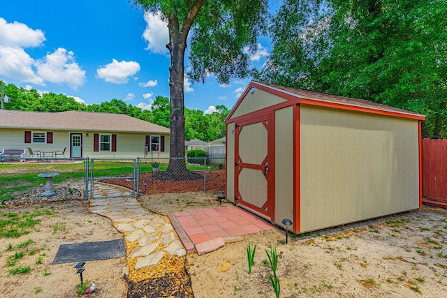 view of shed with fence private yard and a gate