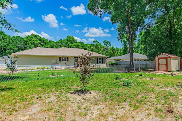 rear view of property featuring a lawn, an outdoor structure, a shed, and a fenced backyard