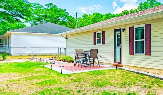 rear view of house featuring a lawn, a patio, and fence