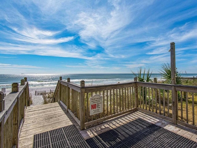 view of home's community featuring a beach view and a deck with water view