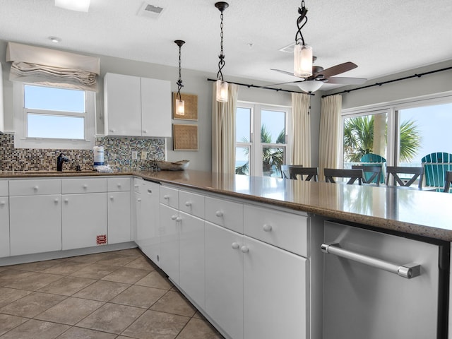 kitchen with visible vents, decorative backsplash, a ceiling fan, a sink, and a wealth of natural light