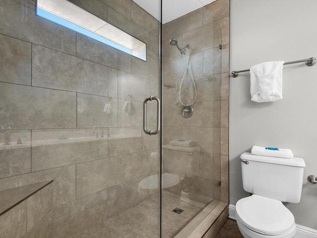 full bath featuring baseboards, a stall shower, and toilet