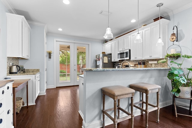4046 17th St, Niceville, FL 32578 - kitchen with stainless steel appliances, backsplash, white cabinetry, crown molding, and recessed lighting