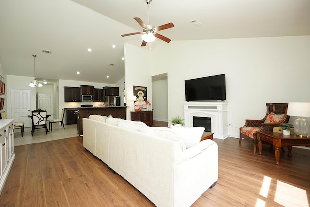 614 Red Fern Rd, Crestview, FL 32536 - living area featuring ceiling fan, light wood-style flooring, high vaulted ceiling, a fireplace, and baseboards